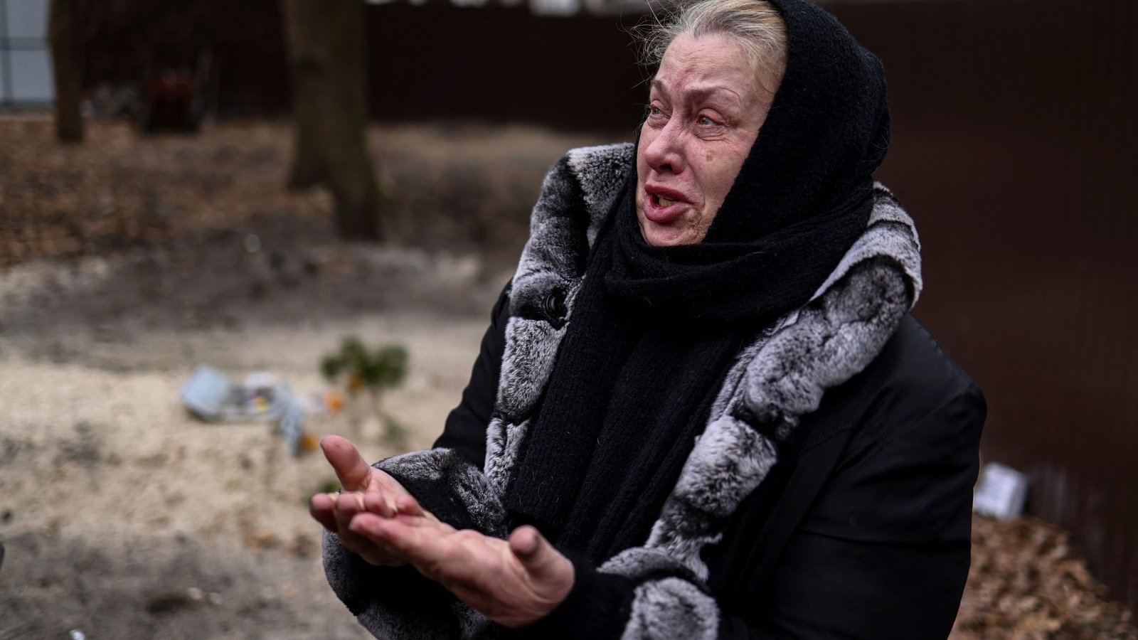 Tetiana Ustymenko weeps over the grave of her son, who was buried in the garden of her house in Bucha, on 6 April 2022