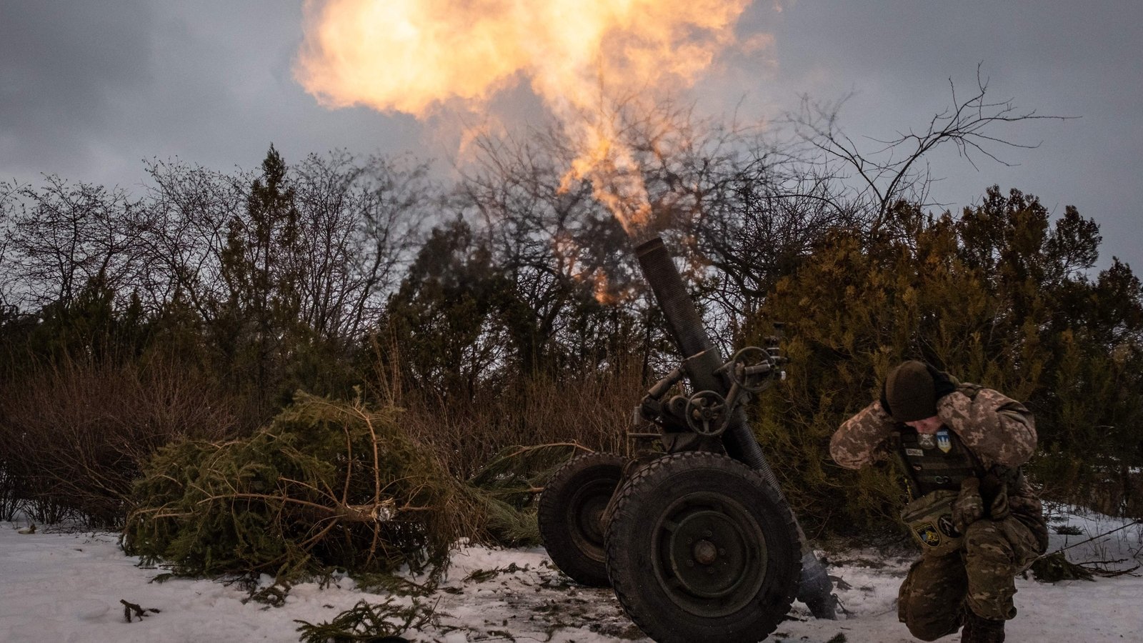 A Ukrainian serviceman of the 93rd brigade covers his ears while firing a French 120mm rifled towed mortar towards Russian positions in Bakhmut on 15 February 2023.