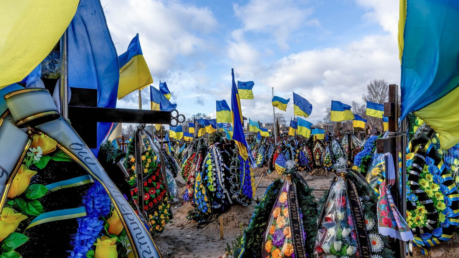 Blue and yellow Ukrainian national flags on the graves of soldiers at a cemetery in Kyiv who were killed during the war.