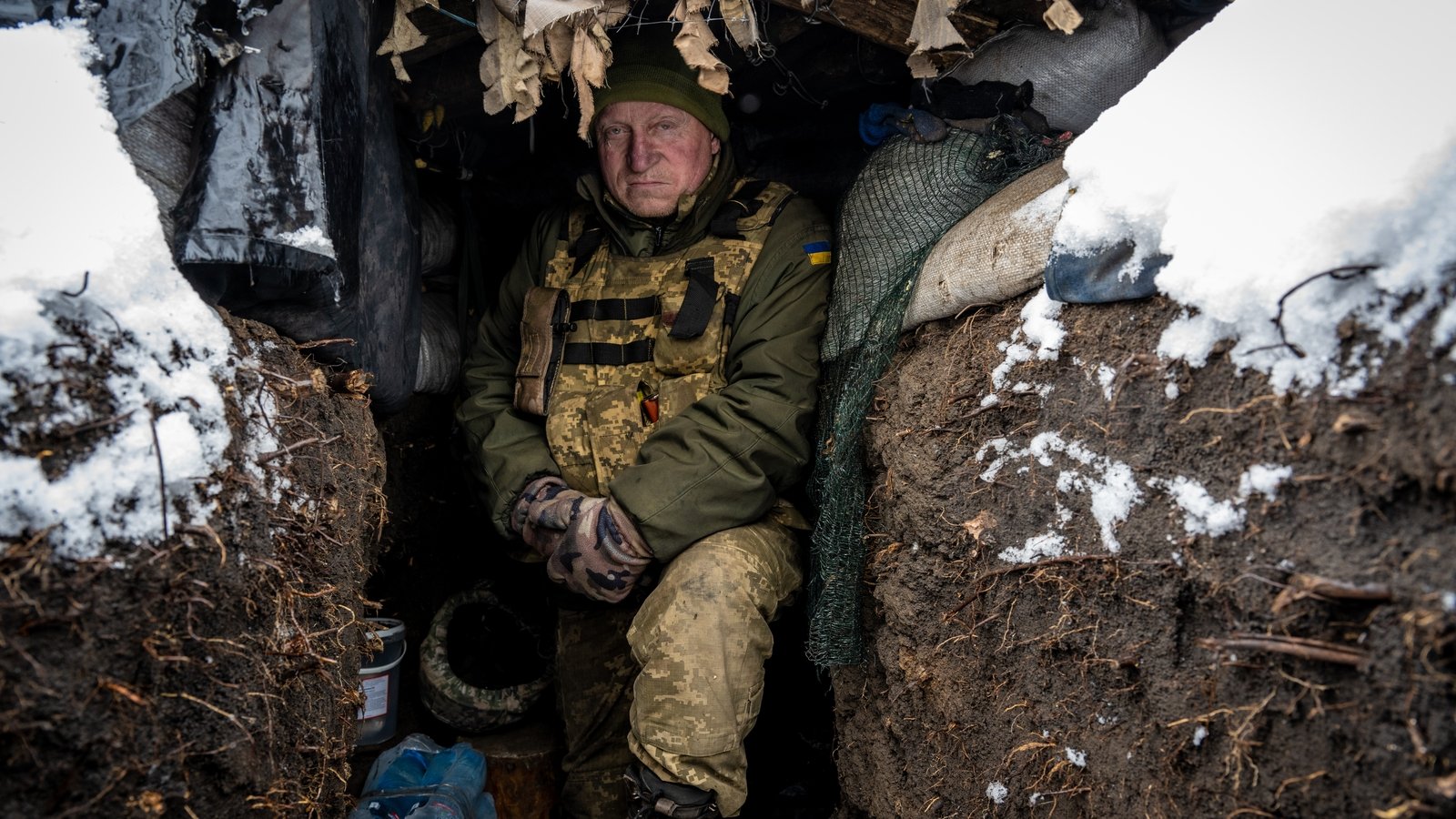 Ukrainian soldier Andrii Wolf Vovk stands amid snow-covered trenches, in which the trees have been shredded by months of Russian shelling, along the frontline in the southern Donbas area of Druzhba.