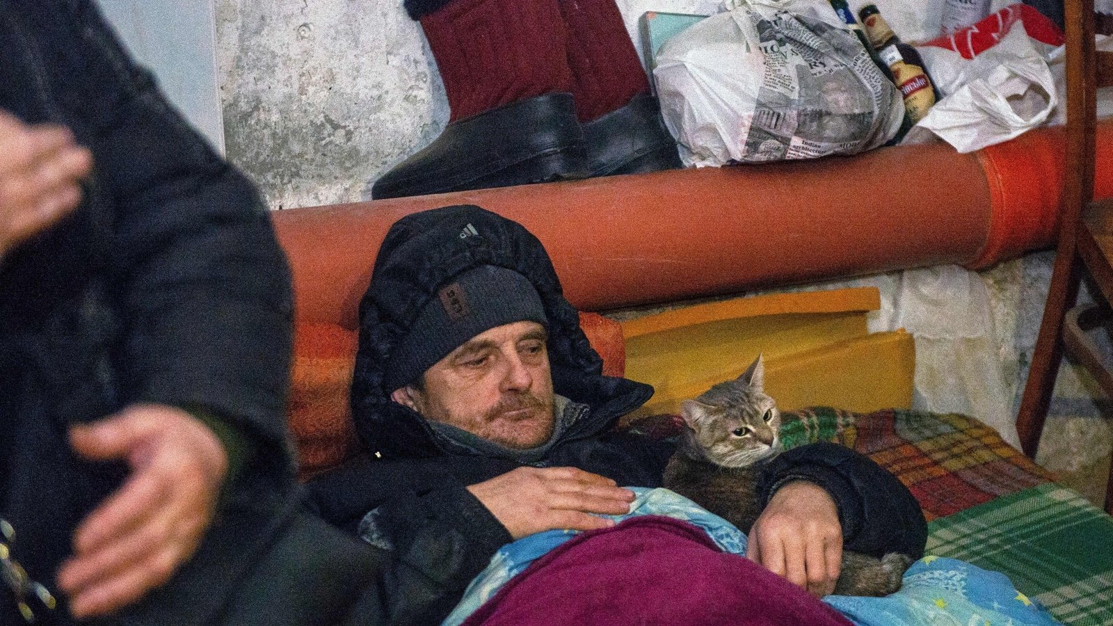 A man and his cat shelter in a basement after Russian troops shelled Ukraine's second largest city, Kharkiv, on the 11th day of the invasion on 6 March 2022.
