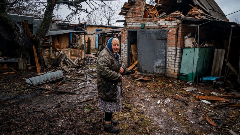 An elderly woman stands in her backyard after shelling in Chasiv Yar, near Bakhmut