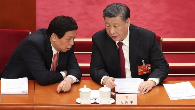 Xi Jinping (R) speaks with Li Zhanshu (L) of National People's Congress (NPC) during the opening of the first session of the 14th National People's Congress