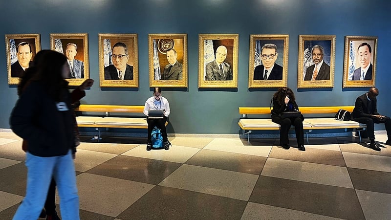Delegates to the Commission on Status of Women event walk past portraits of former UN Secretaries-General
