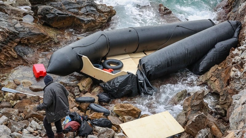 A man stands next to a damaged migrant boat in Thermi on the Greek island of Lesbos in February