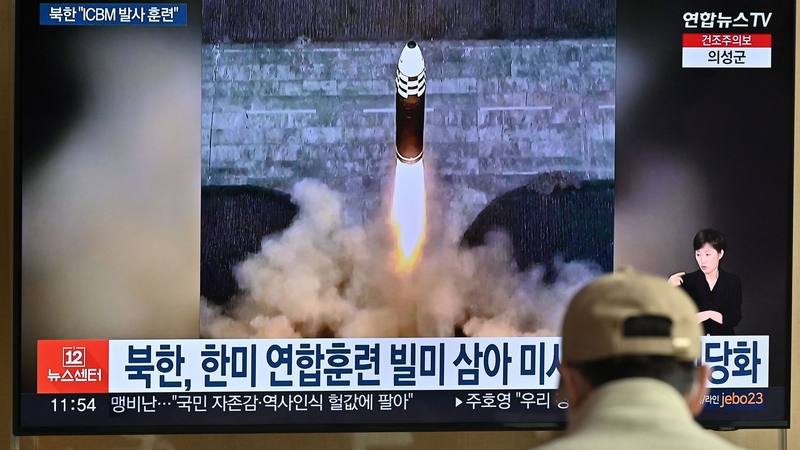 A man watches a television news screen showing a picture of North Korea's recent test-firing of a Hwasong-17 intercontinental ballistic missile (ICBM), at a railway station in Seoul