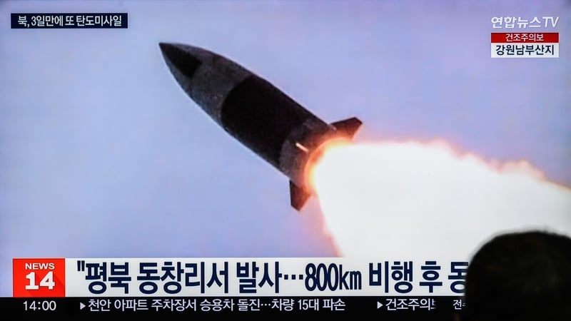 People in South Korea watch a television screen showing a news broadcast with file footage of a North Korean missile test