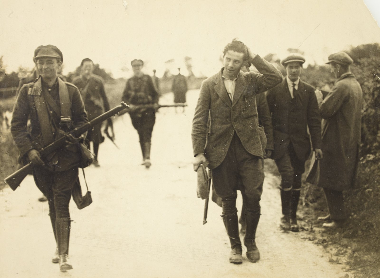 Soldiers bring in a prisoner, satisfied with their day's work. (Credit: National Library of Ireland)