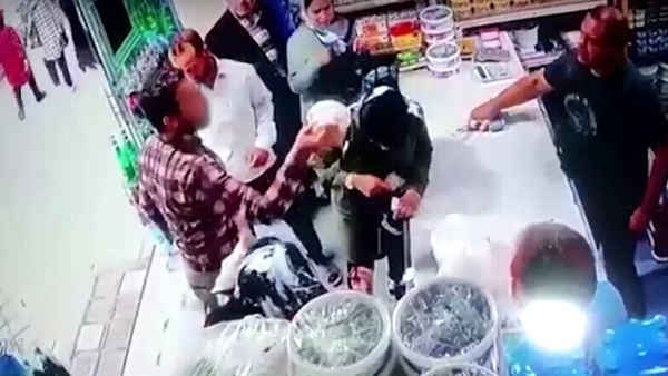 The footage shows the man pouring a bucket of what appears to be yoghurt on the two women's heads