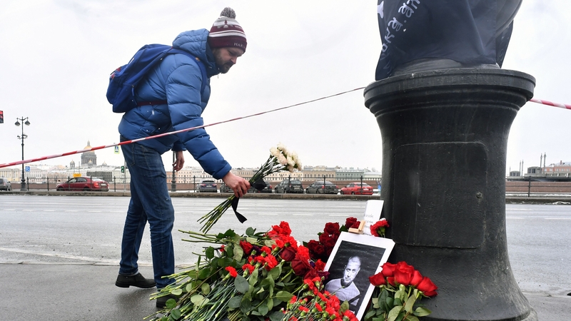 A man lays flowers at a makeshift memorial for Russian military blogger Vladlen Tatarsky