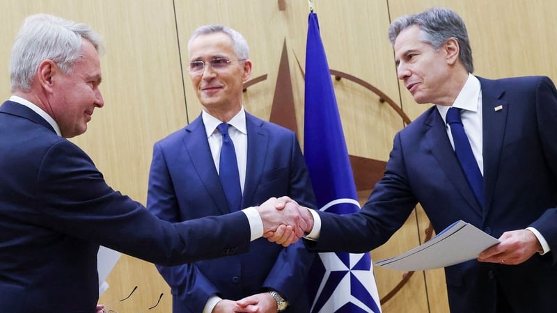 Finnish Foreign Affairs Minister Pekka Haavisto (L) shakes hands with US Secretary of State Antony Blinken, flanked by NATO Secretary-General Jens Stoltenberg (C) as he hands over Finland's accession to NATO documents