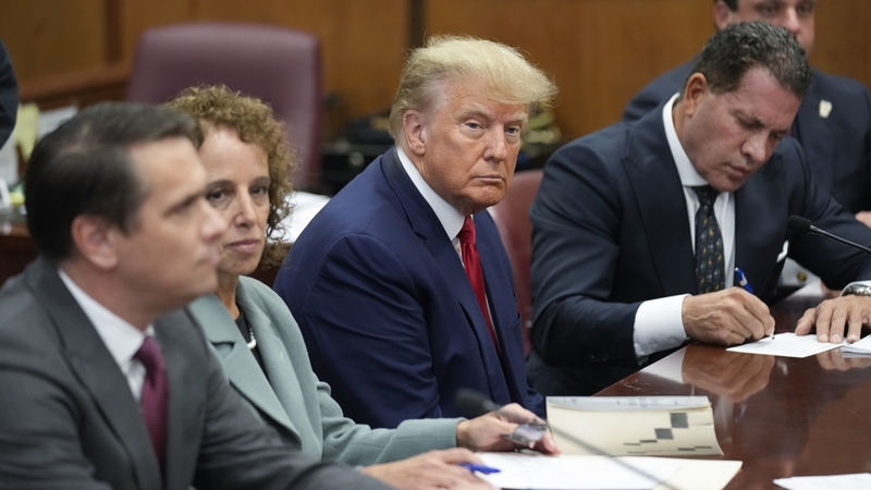 Flanked by his lawyers, Donald Trump sits at the defence table in the courtroom