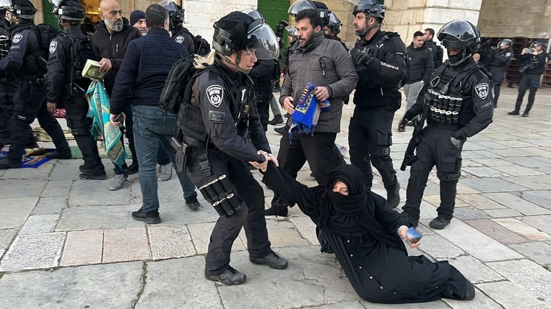 Israeli security forces remove Palestinian worshippers sitting on the grounds of the Al-Aqsa mosque compound