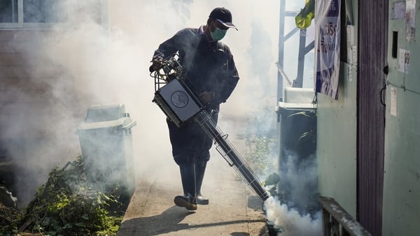 A Thai health officer sprays chemicals to kill mosquitos in Bangkok, Thailand