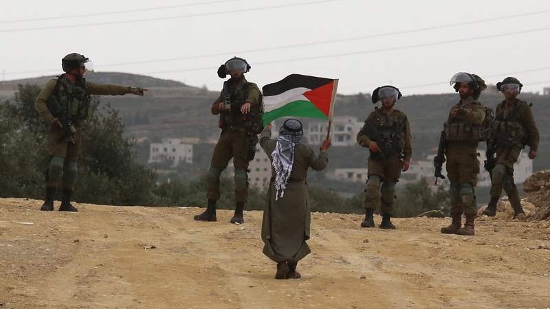 Palestinians react to the march organised by Israeli settlers held to demand legalisation of a settlement outpost in West Bank