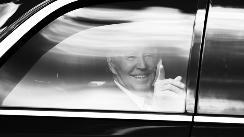 Joe Biden gestures to photographers as he leaves Áras an Uachtaráin in 'The Beast' on route to Farmleigh