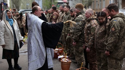 A priest blesses Ukrainian soldiers during a church service on the eve of the Orthodox Easter
