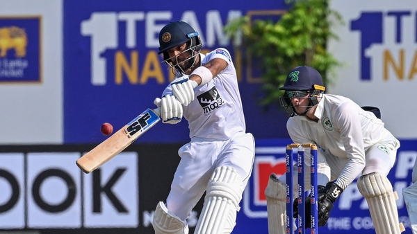 Sri Lanka's Kusal Mendis (L) playing a shot as Ireland's wicketkeeper Lorcan Tucker watches on