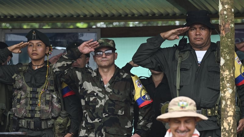 EMC commander Ivan Mordisco (centre) gives a military salute next to other high ranking group members