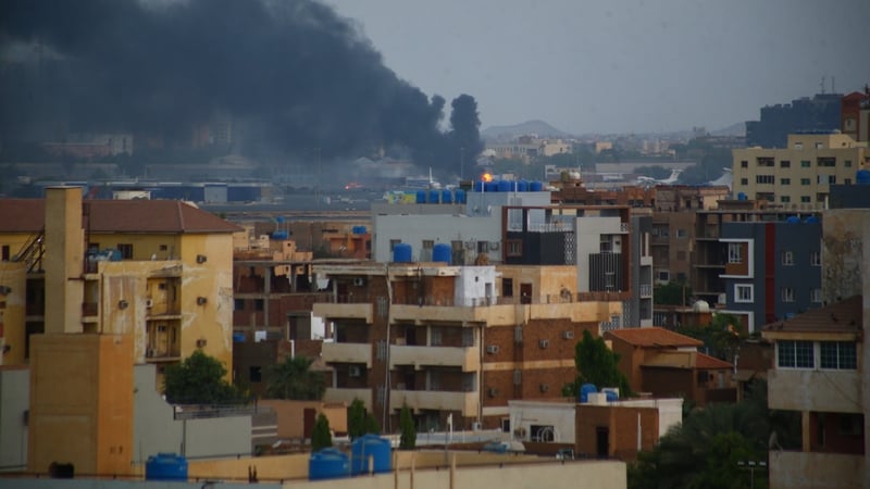 Smoke rises from distant buildings as clashes continue in the Sudanese capital