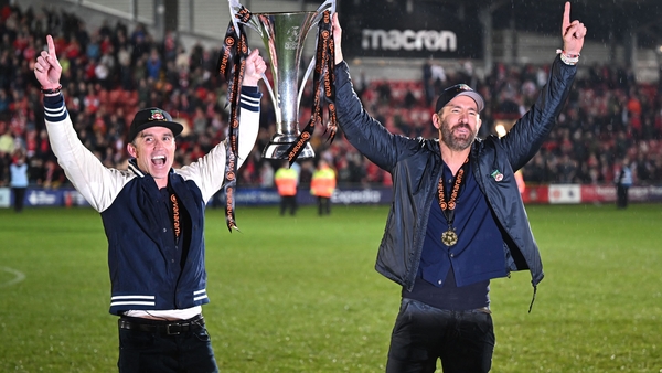Rob McElhenney (L) and Ryan Reynolds (R) celebrate with the National League trophy