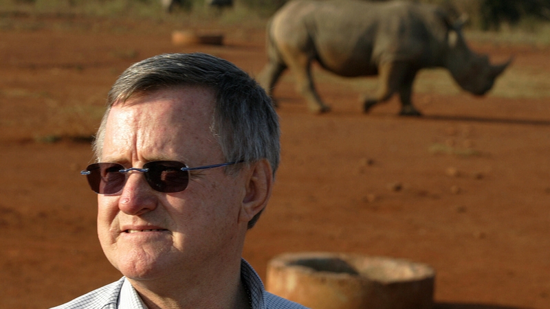 Zimbabwe-born, multi-millionaire game farmer John Hume in front of a black male rhinoceros
