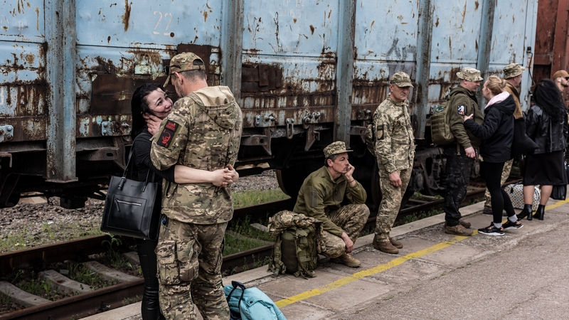 Ukrainian soldiers in Kramatorsk saying goodbye as their loved ones board trains headed for the capital, Kyiv