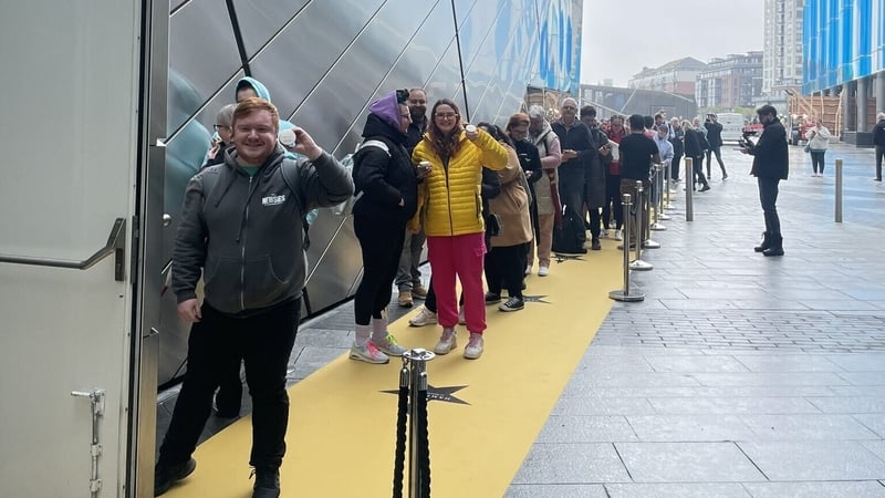 Andrew Dawson waves from the top of the queue outside the Bord Gáis Theatre
