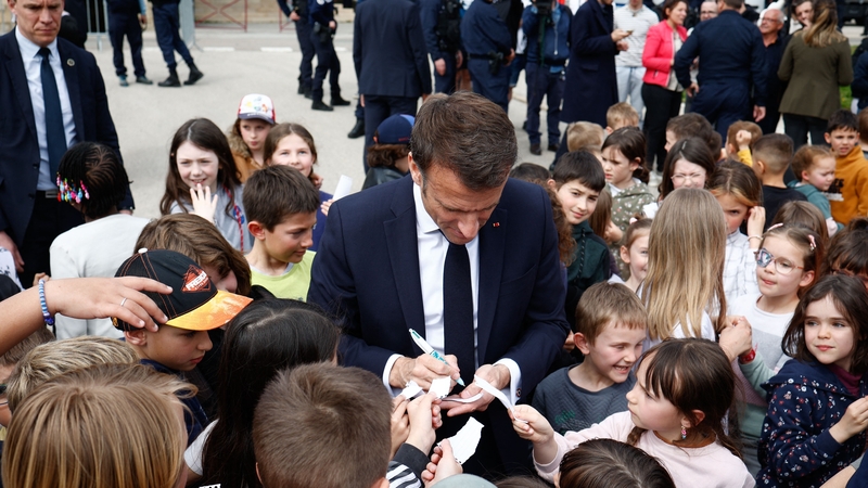 Emmanuel Macron meets children at a school during a visit to attend a ceremony marking the 175th anniversary of the abolition of slavery, in La Cluze-et-Mijoux, eastern France, on 27 April