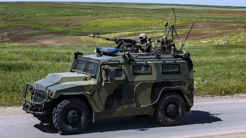A soldier operates a machine gun mounted on an army vehicle during a Turkish patrol in the countryside of Rumaylan in Syria's northeastern Hasakeh province