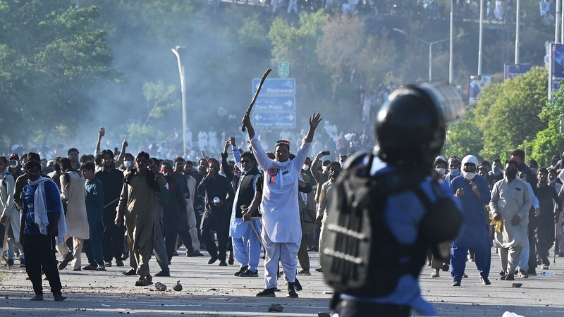 Pakistan Tehreek-e-Insaf (PTI) party activists and supporters of former Pakistan's Prime Minister Imran Khan clash with police outside the police headquarter where Khan was kept in custody