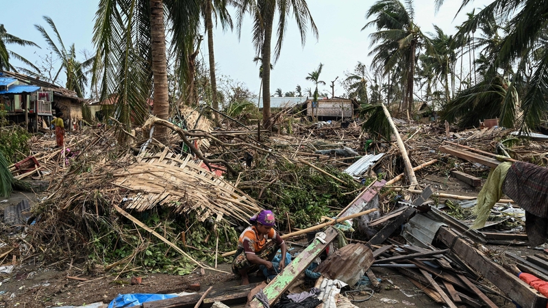 A woman sits in her destroyed house at Basara refugee camp after cyclone Mocha made landfall