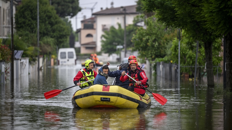 Firefighters evacuated residents in a dinghy across flooded streets in Lugo