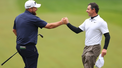 Lowry and McIlroy embrace after their round