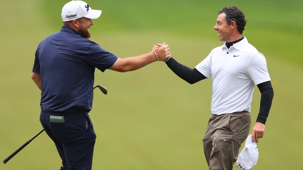 Lowry and McIlroy embrace after their round