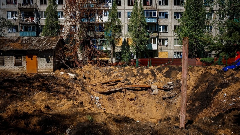 A damaged residential building and crater, after missile strikes in Chasiv Yar near the frontline city of Bakhmut