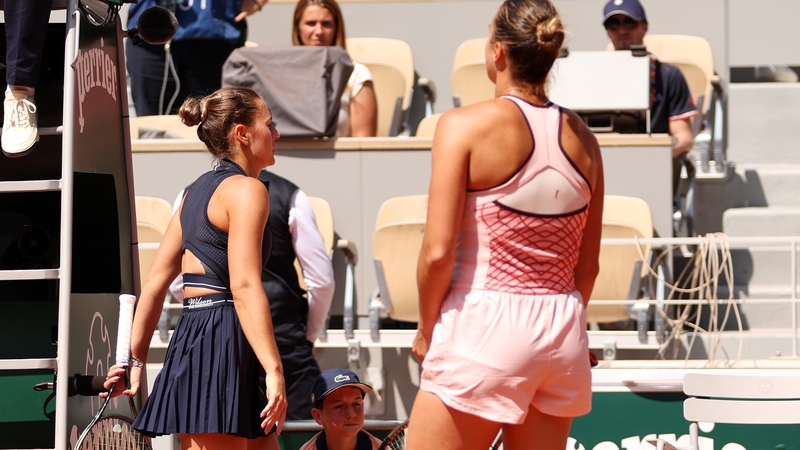Marta Kostyuk (L) walks past Aryna Sabalenka after their first-round match