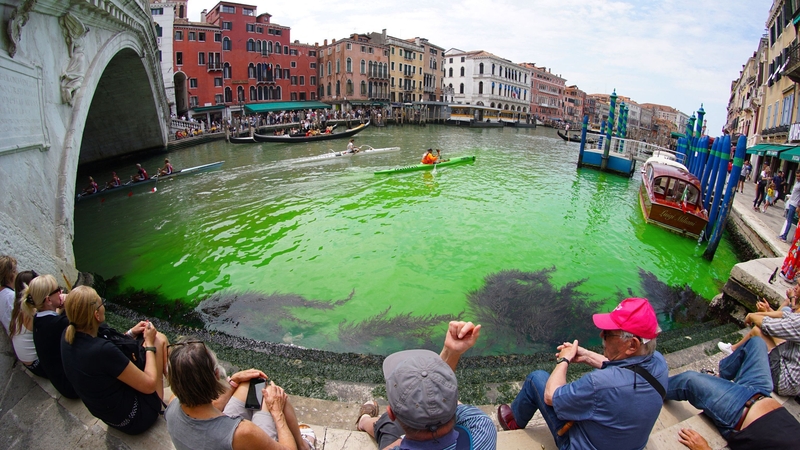 Tourists took photographs of the green area, from the Rialto Bridge up and along part of the Canal