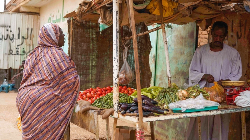 A woman buys vegetables at a street stall in Omdurman, the capital's twin city in war-torn Sudan