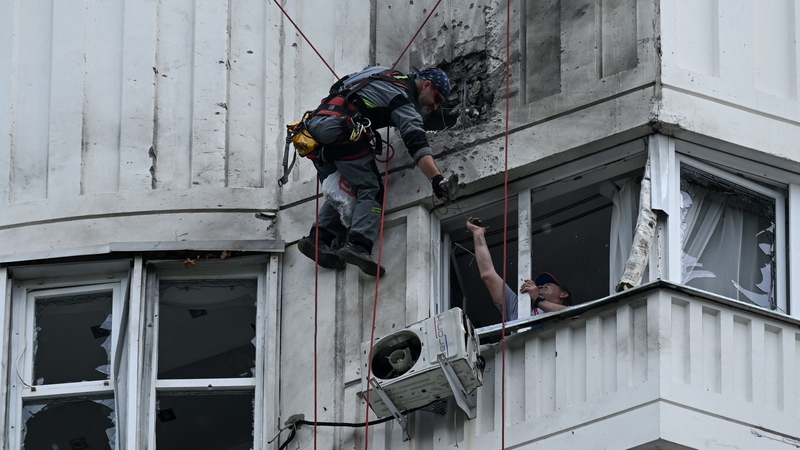 A worker inspects the damaged facade of a multi-storey apartment building in Moscow today