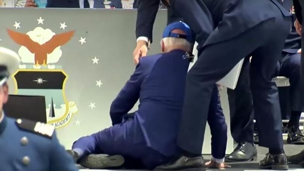 The 80-year-old president quickly got up on one knee helped by three people and walked back to his seat unassisted