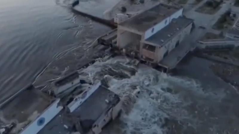 Maidhm mhór uisce ag sceitheadh tríd an bpoll sa damba