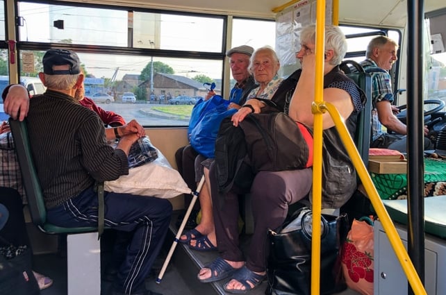 People with their belongings wait for evacuation. About 42,000 people are at risk from flooding in Russian and Ukrainian-controlled areas along the Dnipro River