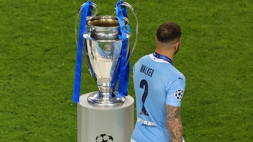 Kyle Walker of Manchester City walks past the UEFA Champions League trophy after the 2021 final