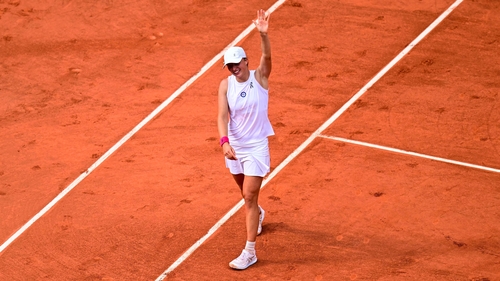 Iga Swiatek waves as she celebrates her victory
