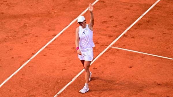 Iga Swiatek waves as she celebrates her victory