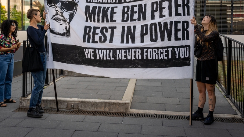 Activists hold a banner ahead of the trial