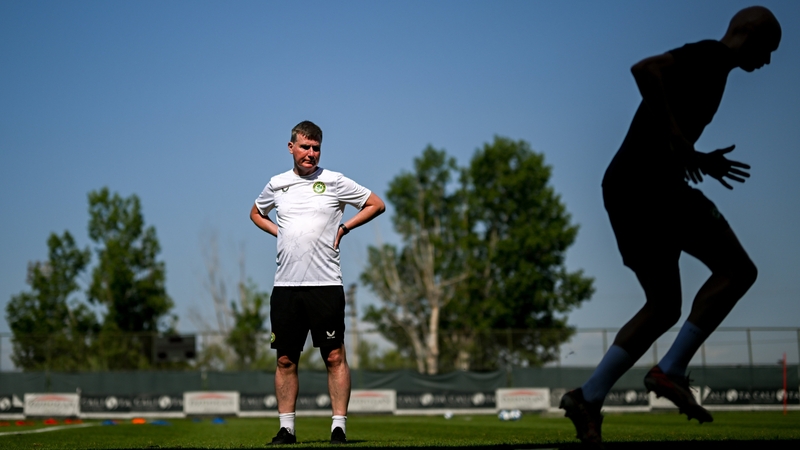 Stephen Kenny conducting a training session in Turkey as a silhouetted Will Smallbone passes the manager