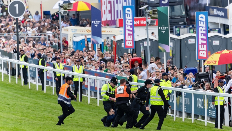 A protestor is hauled off the track during the running of the Derby at Epsom earlier this month
