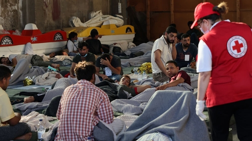 Rescued people find shelter at a depot, following the shipwreck off Greece
